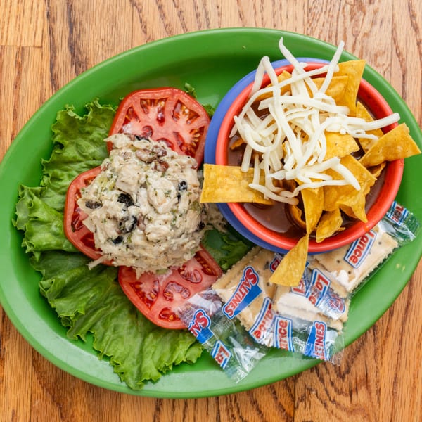 Southern chicken salad on lettuce and tomato, with chili, tortilla chips, cheese, and crackers.